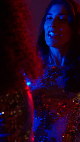 Vertical-Video-Of-Two-Women-In-Nightclub-Bar-Or-Disco-Dancing-With-Sparkling-Lights-In-Background-4